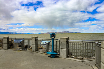 A blue scenic view finder overlooking the Great Salt Lake in Utah with white clouds and mountain ranges in the background.