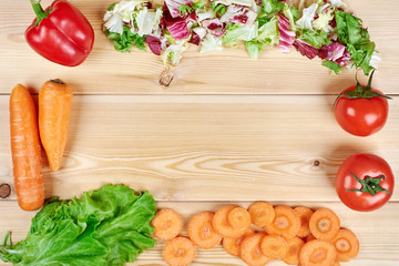 Frame of fresh vegetables on wooden background. Healthy natural food on table with copy space . Cooking ingredients top view, mockup for recipe or menu.