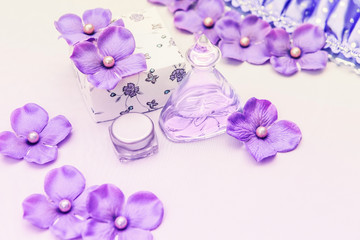 perfume bottle with a box and some purple and pink decorations on white background, woman cosmetics