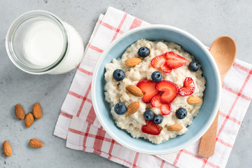 Oatmeal porridge with fresh berries and nuts in a bowl top view. Healthy lifestyle, healthy eating, dieting, fitness and vegetarian food concept