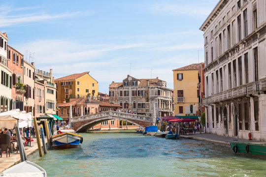 Fototapeta View of The Venice street, colorful houses and canal with boats and Guglie bridge in Venice sunny day, Italy.