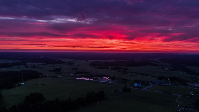 Aerial view of green fields with clouds above at sunset. Drone sunset timelapse footage. Summer nature  landscape.