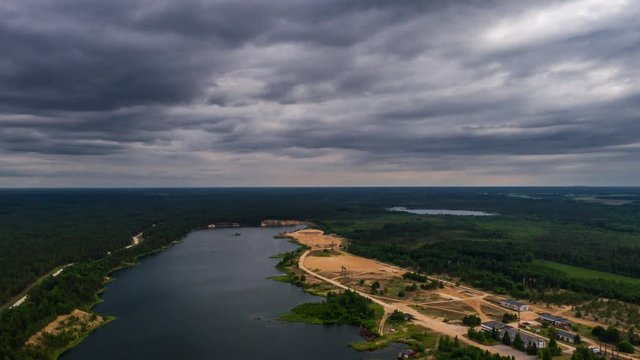 Aerial view of lake and massive clouds above. Drone timelapse footage. Summer nature landscape.
