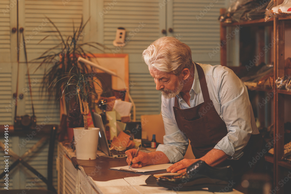 Wall mural Elderly man in the workshop