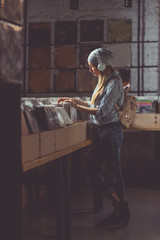 Young attractive girl browsing records indoors