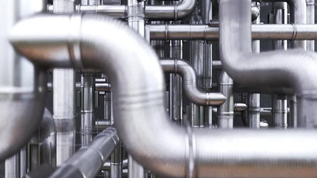 The camera moving over the maze of shiny, clean metal pipes tangled together.
