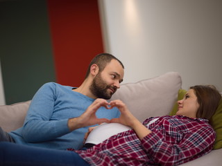 man and pregnant woman showing heart sign