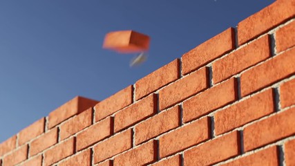 The clay brick wall being build at clear blue sky background. Loopable