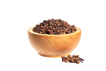 Dried cloves in a wooden bowl on a white background