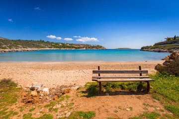 Naklejka na ściany i meble Empty bench at Marathi bay beach on Crete, Greece