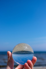 chrystal ball on a mans palm on the beach