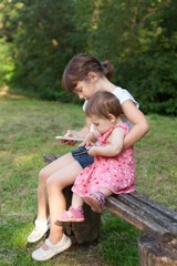 Cute little girls are playing games on cell phone.