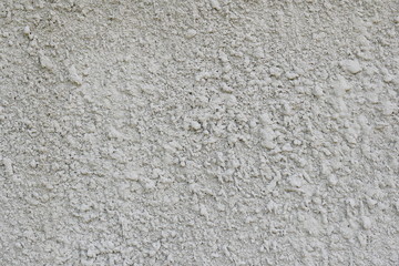Gray, cement, concrete wall with irregularities as background texture of light shade in daylight