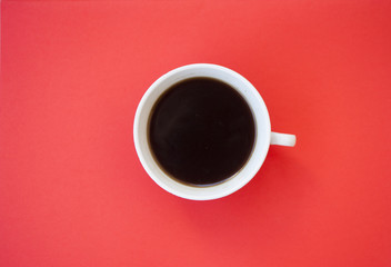 A cup of coffee on red background.
