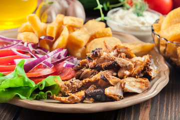 Greek gyros dish with french fries and vegetables