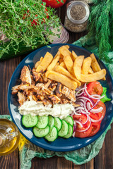 Greek gyros dish with french fries and vegetables