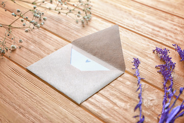 Envelope and flowers on color wooden background