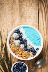 Blue smothie in bowl with granola and berries