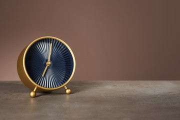 Alarm clock on table against color background. Time management concept