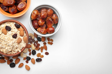 Composition with oatmeal flakes, dry fruits and nuts on white background