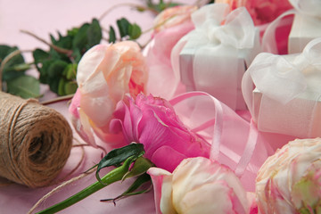 Beautiful flowers and gift boxes on color background, closeup
