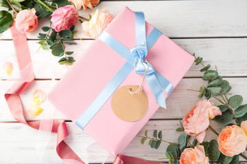 Beautiful flowers and gift box on wooden background