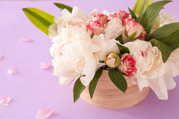 Box with beautiful flowers on color background, closeup