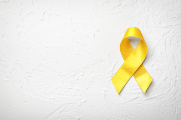 Yellow ribbon on light background. Cancer concept