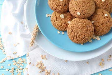 Plate with delicious oatmeal cookies on wooden background