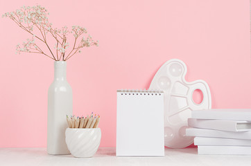 Creativity school background for girl's - white stationery, palette, pencils and blank notepad on soft pink wall and white wood desk.
