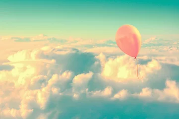 Poster Pink air balloon flying high in the sky above the clouds, vintage process © Delphotostock