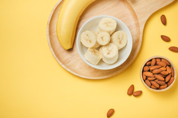 Bananas and banana slices on a plate of wood.