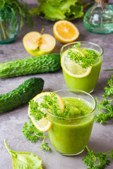 Refreshing smoothies from cucumber, green apple, fresh herbs and lemon juice in transparent glasses...