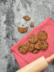 Still life of freshly baked chocolate chip cookies on plate on table.