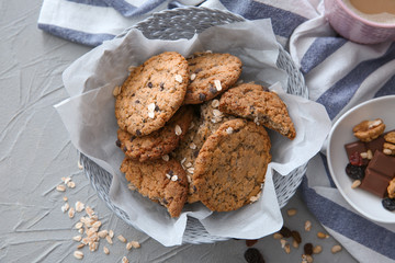 Wicker bowl with delicious oatmeal cookies on table