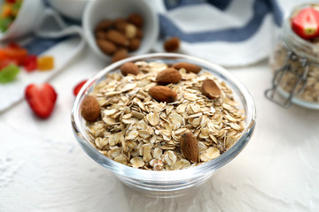 Bowl with raw oatmeal and nuts on table