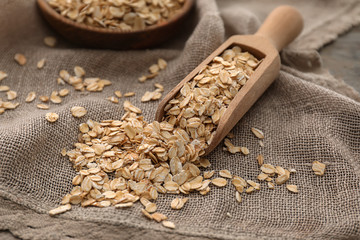 Wooden scoop with raw oatmeal on napkin