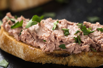 Liverwurst Sandwich with chopped parsley on a dark slate