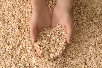 Female hands with oatmeal flakes, closeup