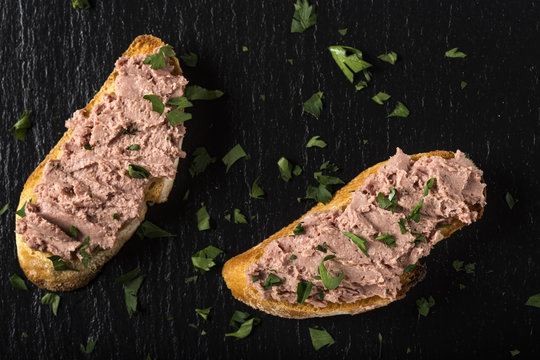Fototapeta Liverwurst Sandwich with chopped parsley on a dark slate