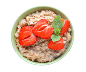 Bowl with tasty oatmeal and strawberry on white background