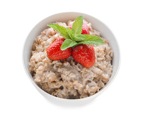 Bowl with tasty oatmeal and strawberry on white background