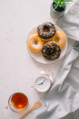 Overhead view of chocolate cake donuts with salted caramel glaze with a cup of espresso on marble table top. Afternoon me time book reading with dessert and coffee. Text space images