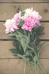 Bouquet of peonies on a wooden background