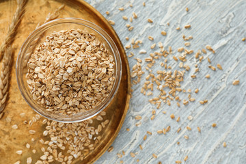 Bowl with raw oatmeal on wooden background
