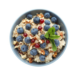Tasty oatmeal with fresh berries and nuts on white background