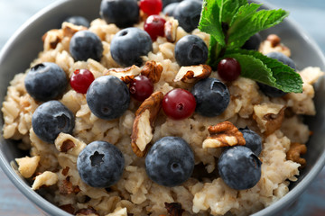 Tasty oatmeal with fresh berries and nuts, closeup