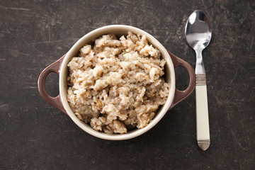 Tureen with tasty oatmeal on grey background