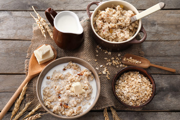 Composition with tasty oatmeal and milk on wooden table