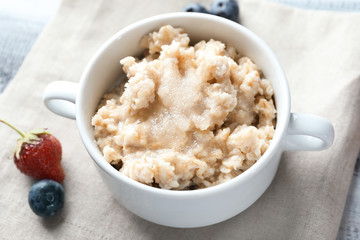 Tasty oatmeal in tureen on table